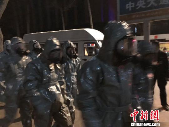 十几名身着防护服的人员头戴面具进入事发地。　胡健 摄